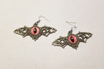 Silver winged pink eyed earrings